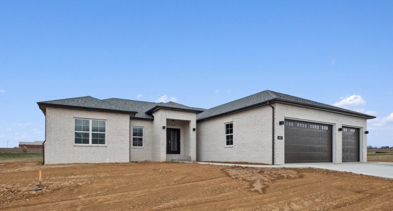 Legacy home designs featuring front and rear elevations with light toned brick exterior, creamy siding, and a stone pillar entryway. Three car garage, with 2 separate bays. Featuring the backyard and covered patio.