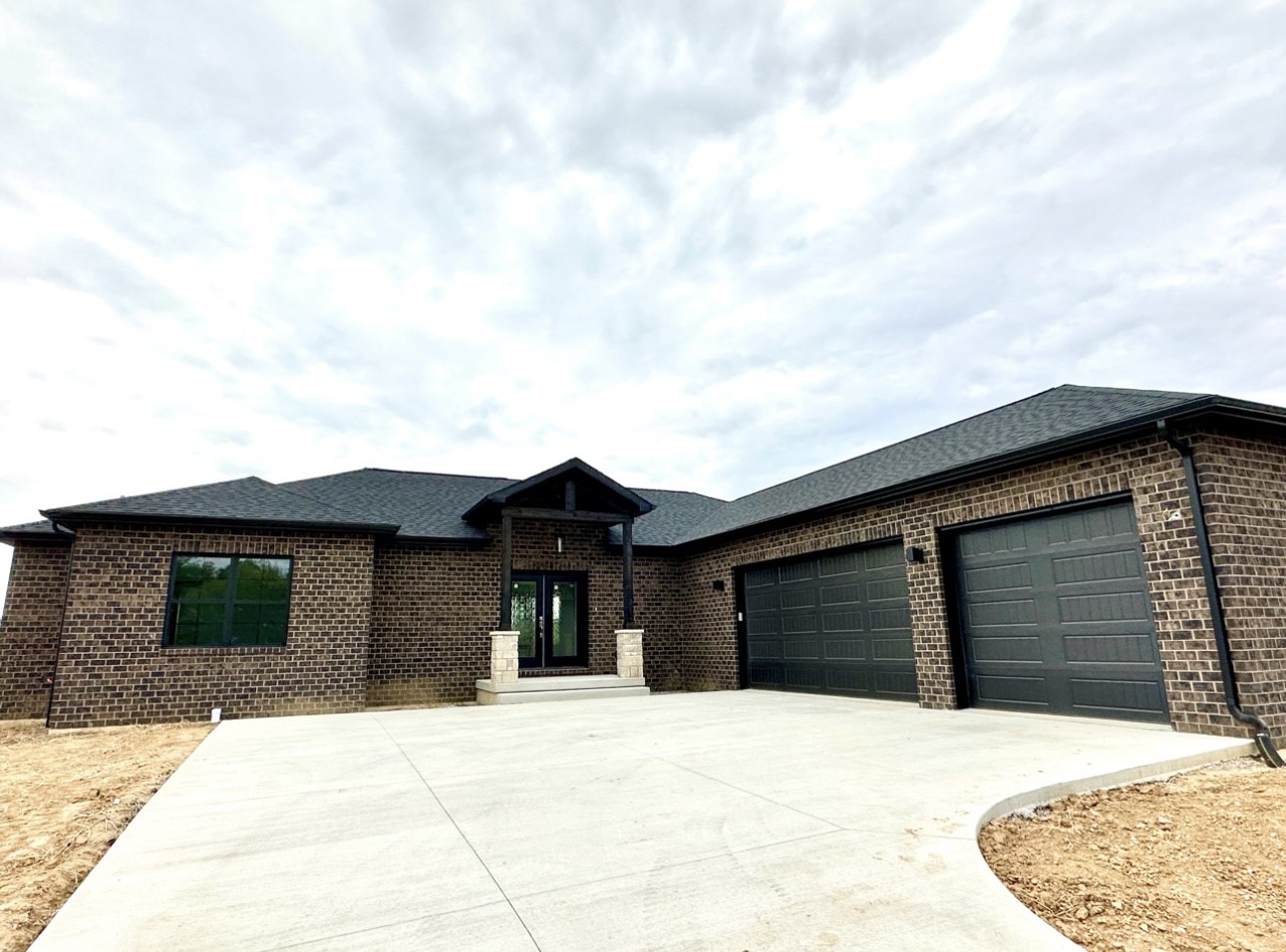 A modern garage with a front entry, featuring dark brickwork and a black exterior.