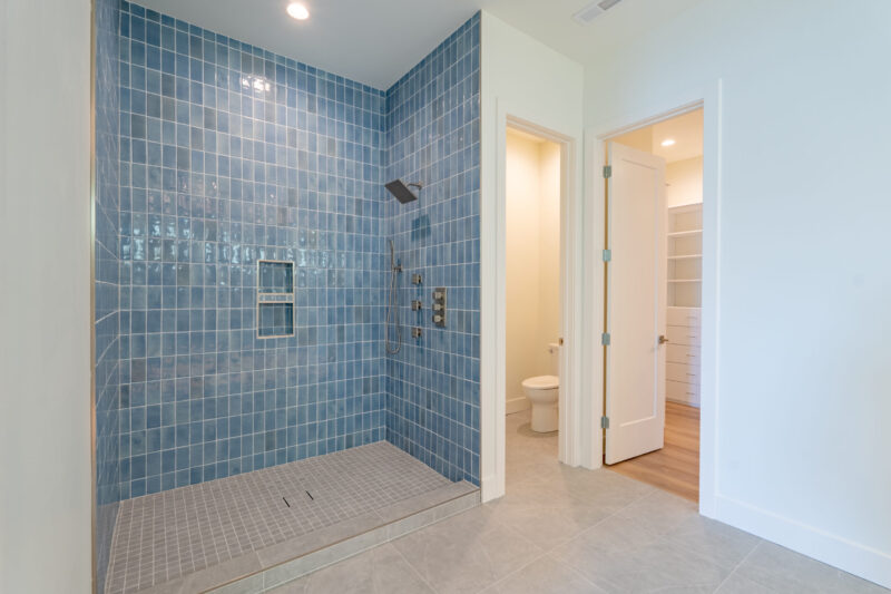 Second Primary basement custom tile shower with beautiful ocean blue tile.