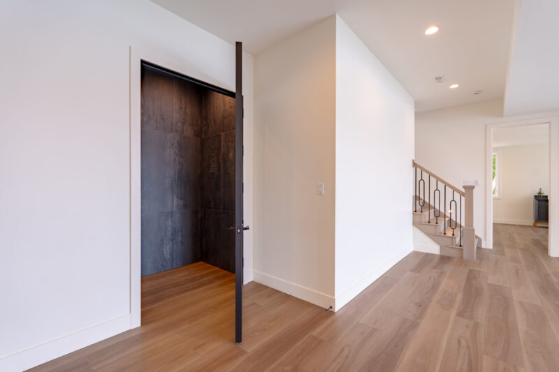 Tiled wine cellar or custom whiskey room with large glass door.