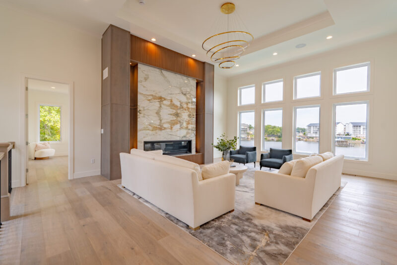 Modern Lake View Great Room with luxurious book matched stone fireplace.