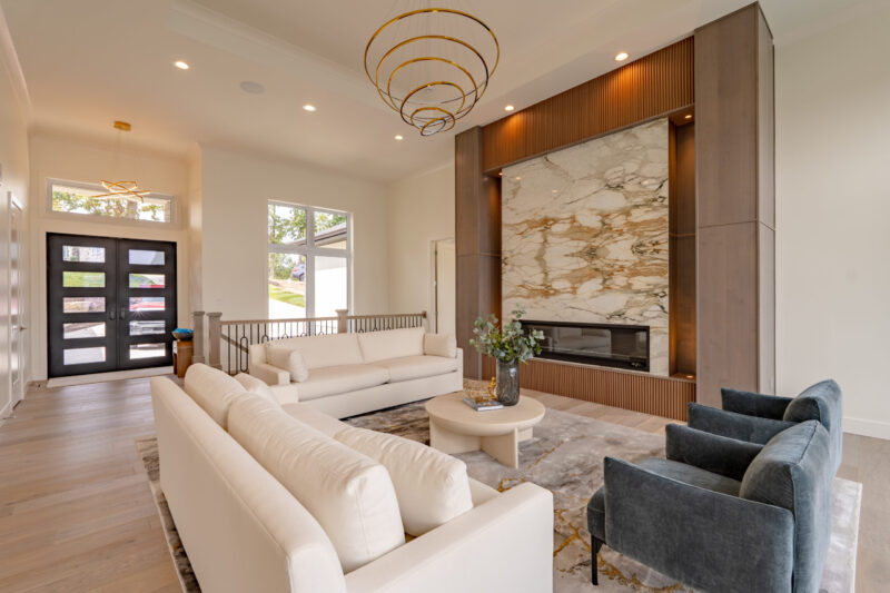 Modern Lake View Great Room with luxurious book matched stone fireplace.