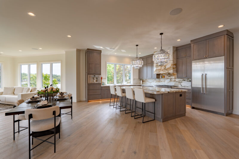 Luxurious large kitchen with custom stained cabinets and elegant countertops, which match the book end stone fireplace in the great room.