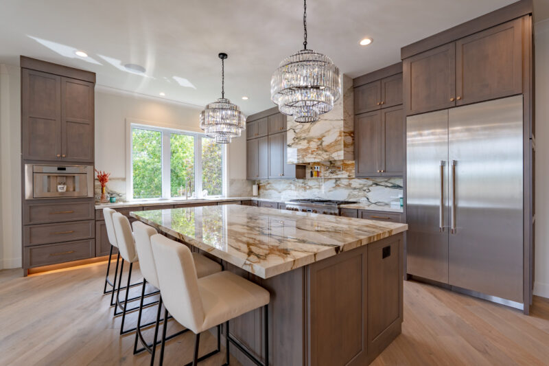 Luxurious large kitchen with custom stained cabinets, large eat in island and elegant countertops. Professional Thermador appliances throughout the kitchen.