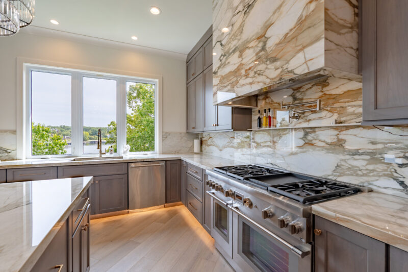 Luxurious large kitchen with custom stained cabinets and elegant countertops. Large porcelain hood vent and professional Thermador appliances. Large picture window overlooks the lake.