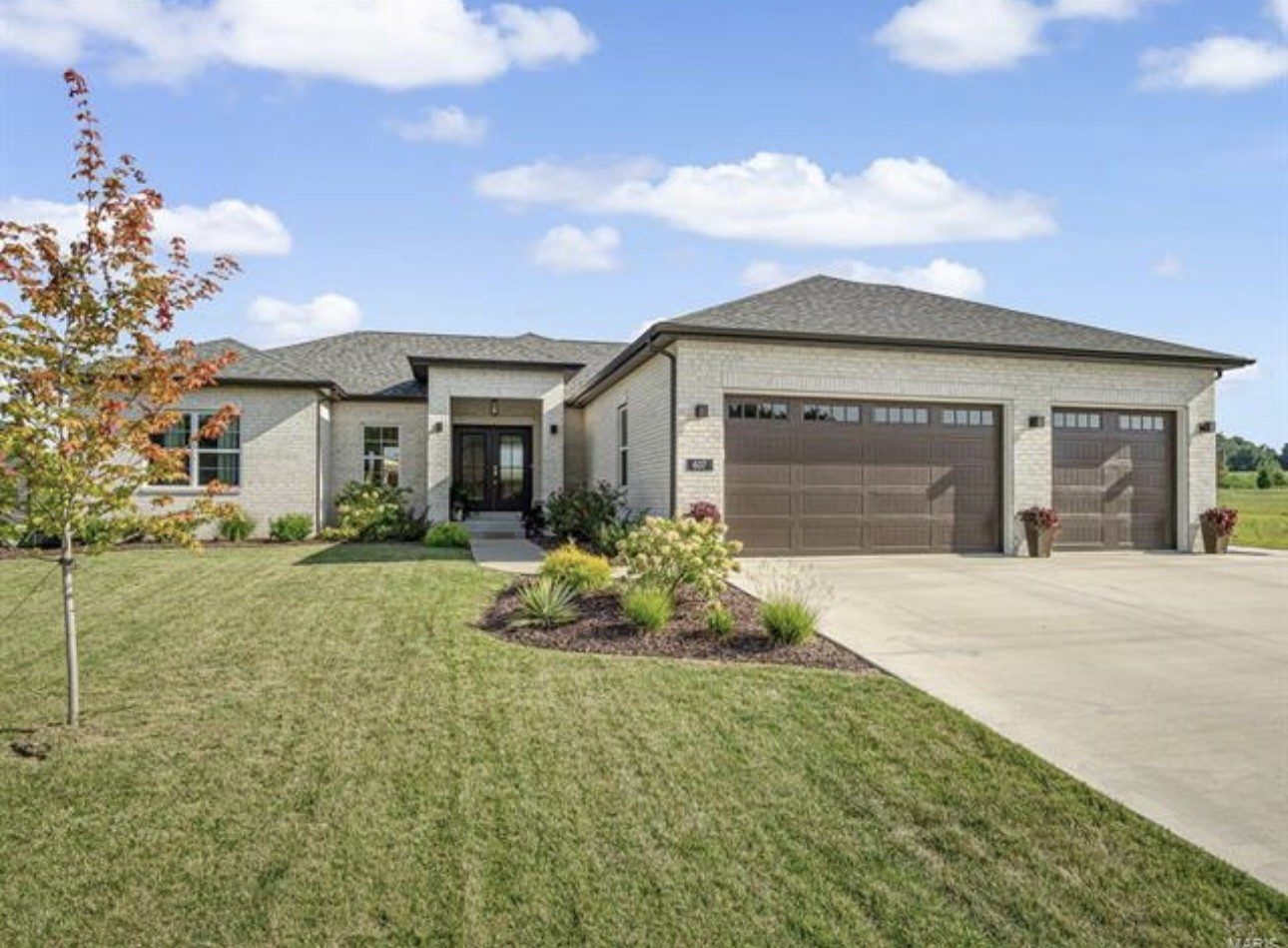 Legacy home designs featuring front and rear elevations with light toned brick exterior, creamy siding, and a stone pillar entryway.